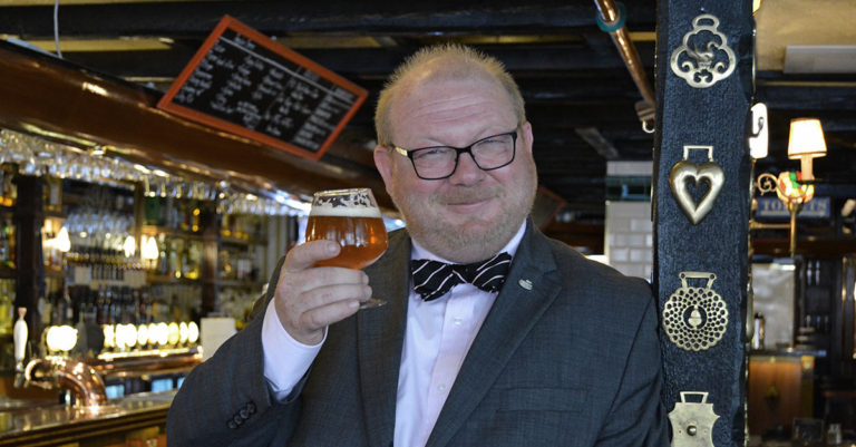 Rick Kempen står i baren med ett ölglas